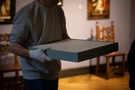 The figure carries a drawing packed in a box